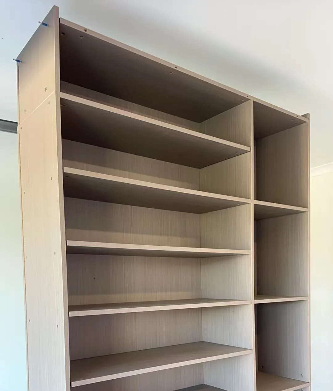 Anonymized indoor photo of a tall bookcase carcass assembled during residential installation.
