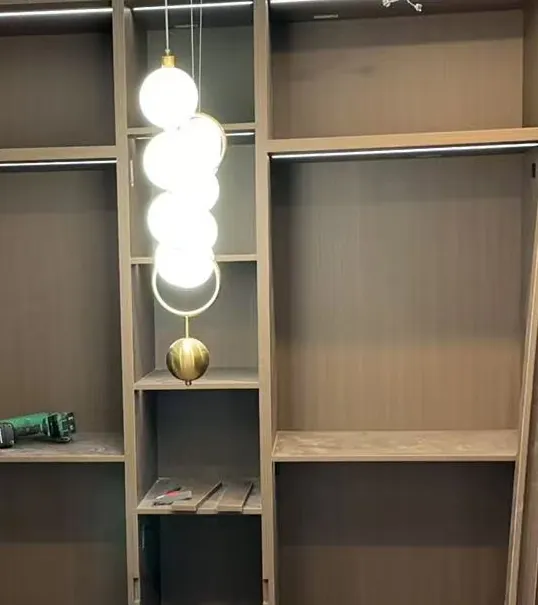 Anonymized walk-in cabinetry with integrated lighting being prepared during installation.