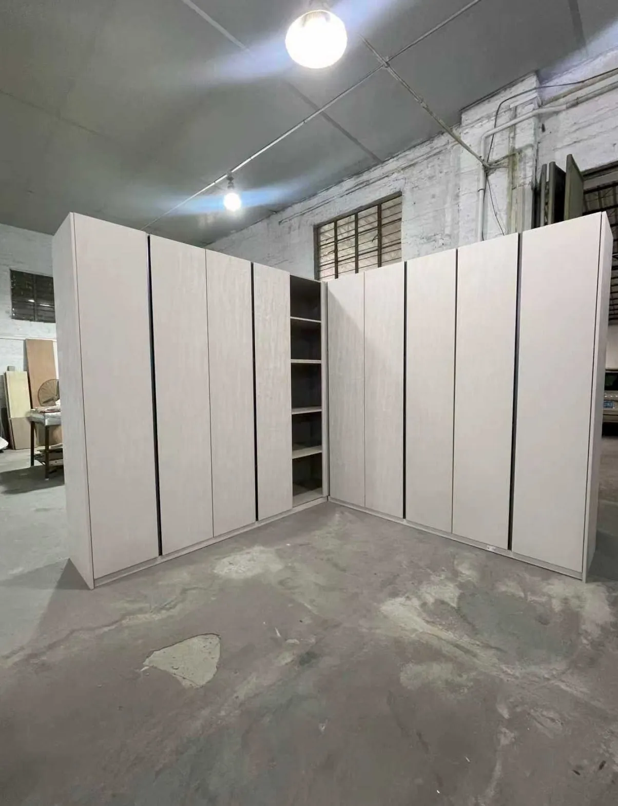 Wardrobe units standing in a factory as a separate anonymized assembly-stage example.